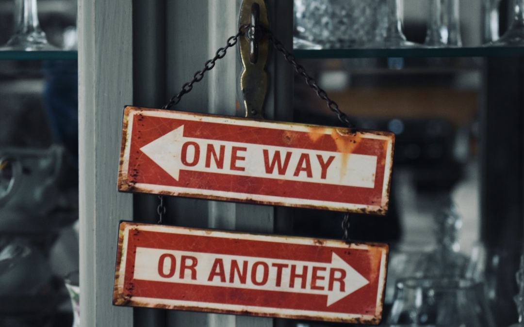 two red and white signs hanging from a metal pole
